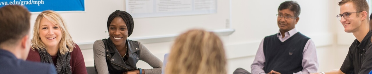Master of Public Health students engage in a small group discussion, while MPH faculty member Dr. Azizur Molla looks on.